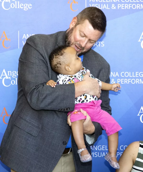 The college president holding a students child