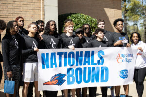 Young men and women outside, smiling and holding a "NATIONALS BOUND" banner with Angelina College and NJCAA logos.