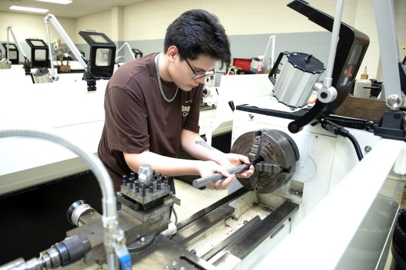 Student operates a metal lathe in a machine tool lab.