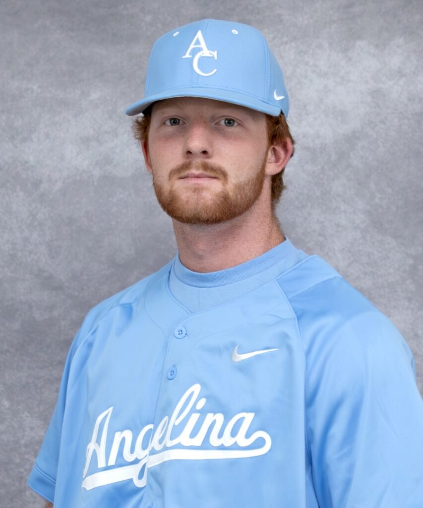 Young man with red hair and beard, in a light blue cap and "Angelina" jersey, poses before a gray mottled background.