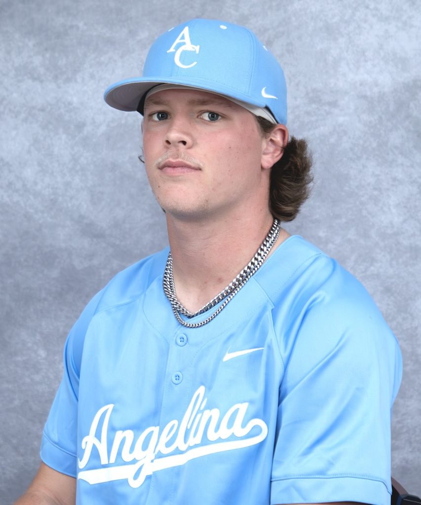 Young baseball player in a light blue Angelina jersey and cap, wearing a chain necklace, stands against a gray background.