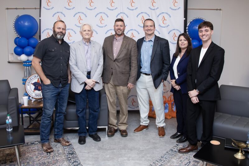 Six people pose for a group photo in front of an Angelina College Student Life backdrop.