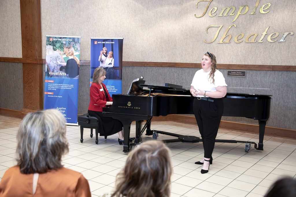 A woman singing, accompanied by a pianist at a Steinway & Sons grand piano in the Temple Theater.